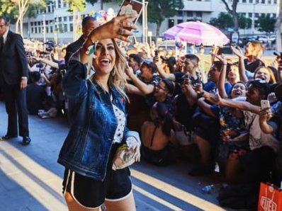 Youtuber fazendo selfie com fãs na rua